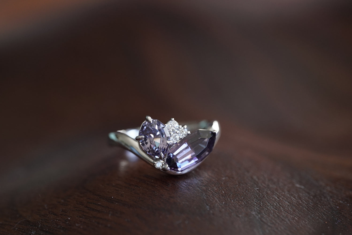 white gold ring with a purple gemstone on a wooden surface