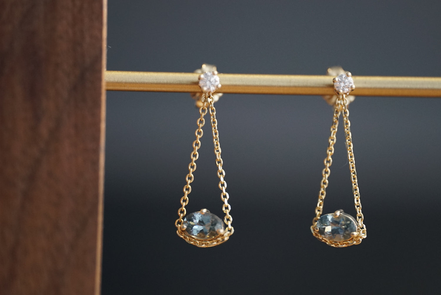 Gold earrings with gemstones on a dark background