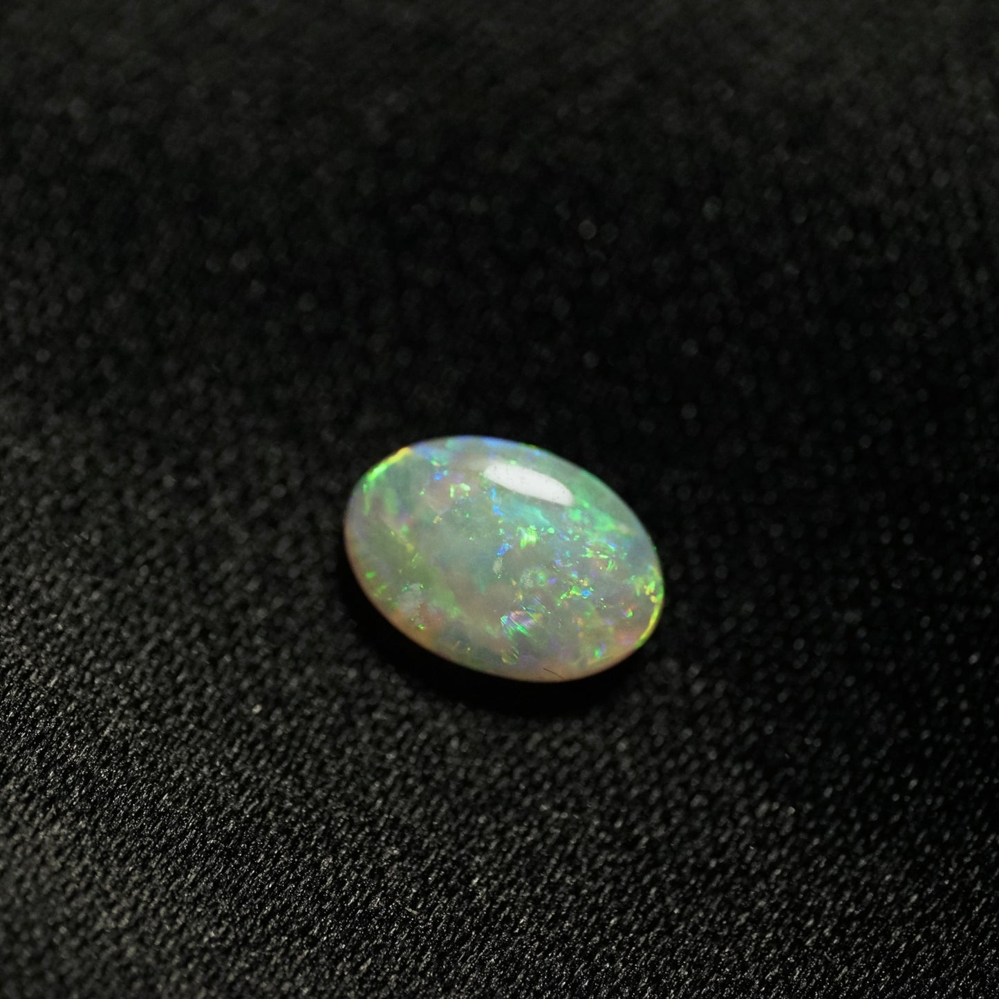 a 1.24 ct oval opal on a black backdrop