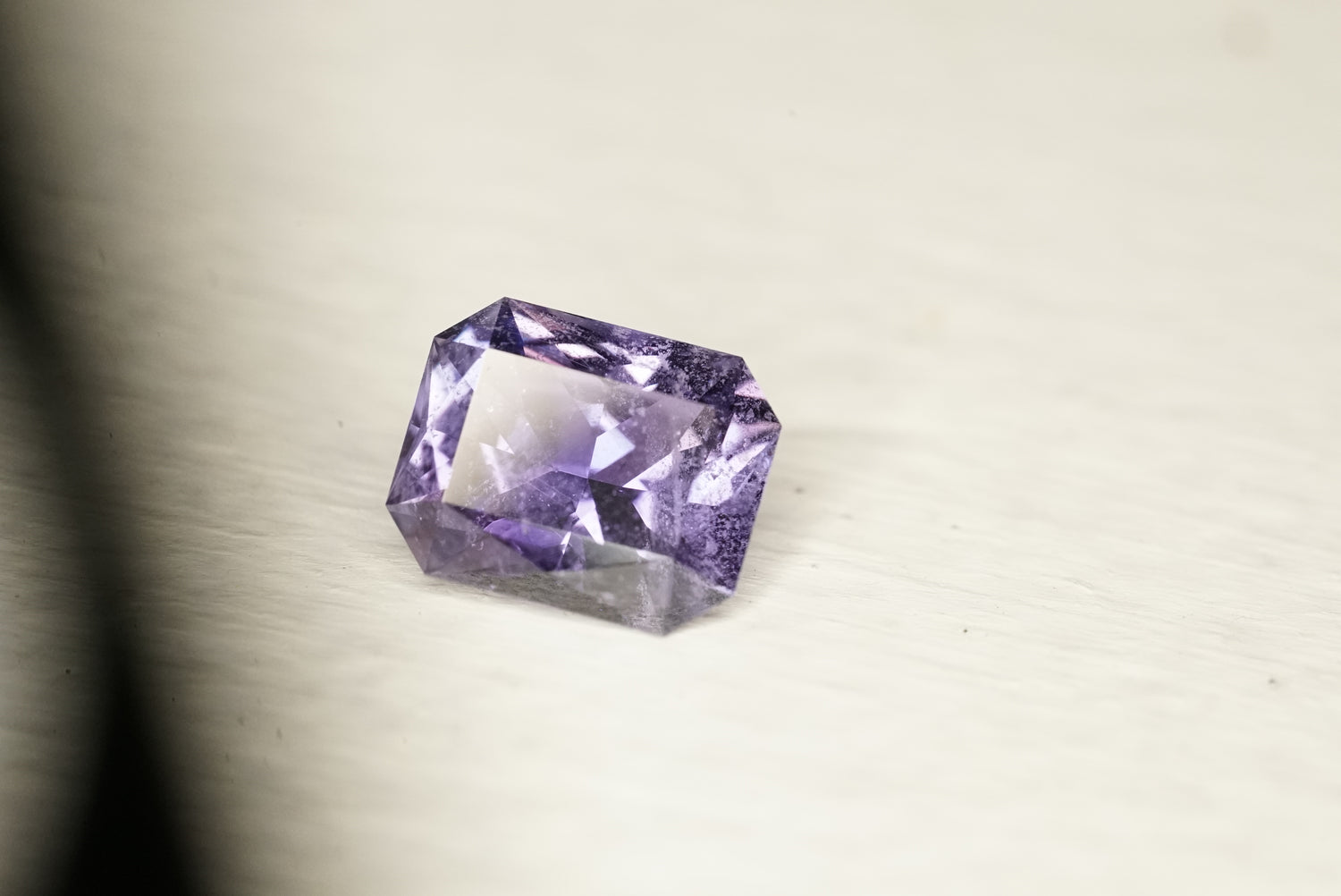 Purple gemstone on a light gray background