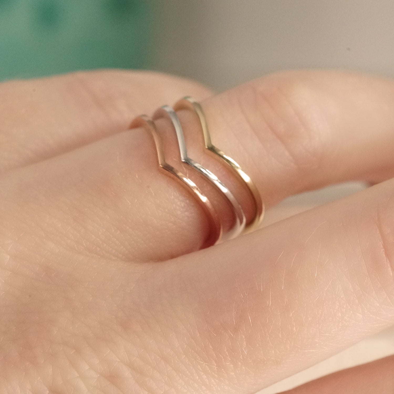 3 shadow style bands shown in white yellow and rose gold on a light skinned left hand