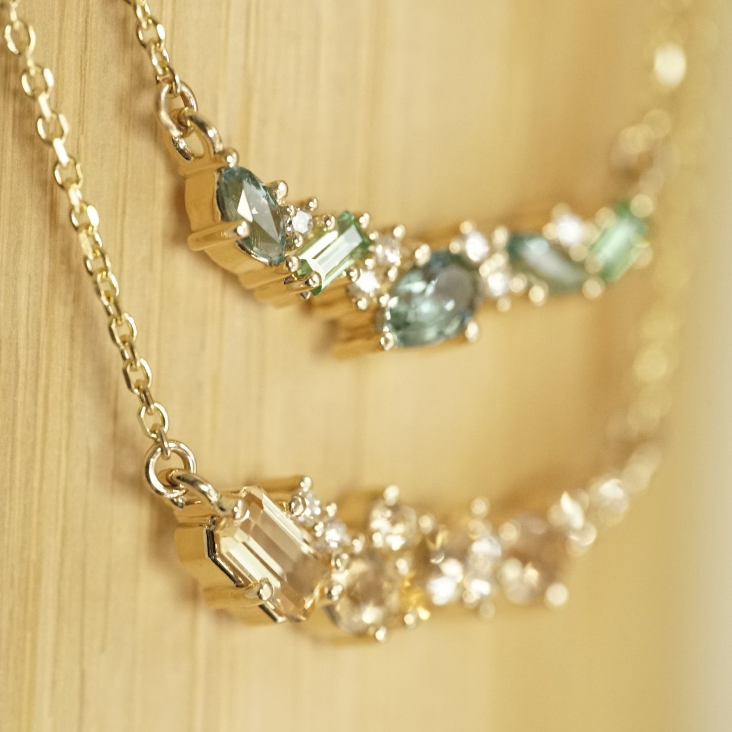 a mixed gem yellow pendant stacked with a mixed gem green pendant on a bamboo background