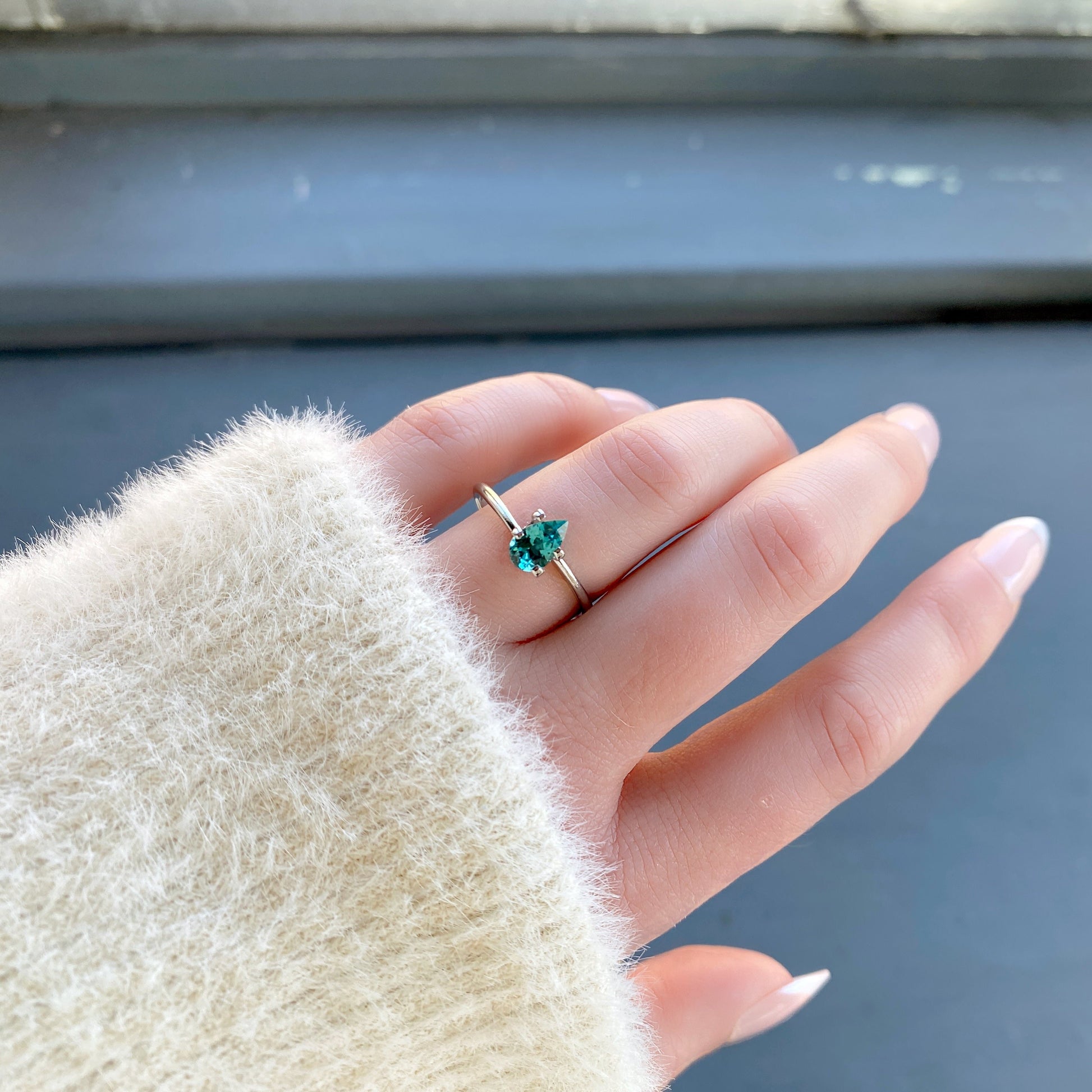 a 0.64 ct pear shape tourmaline in a temporary ring mounting in diffused winter sunlight