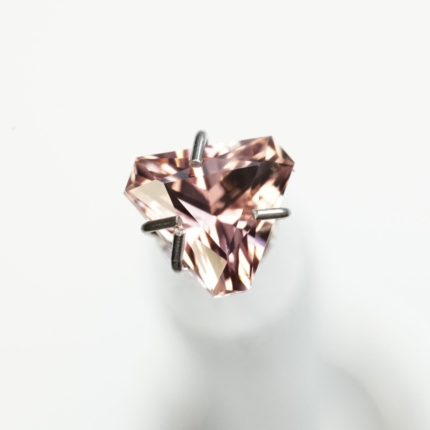 a 0.85 ct pink tourmaline trillion rests on a white base