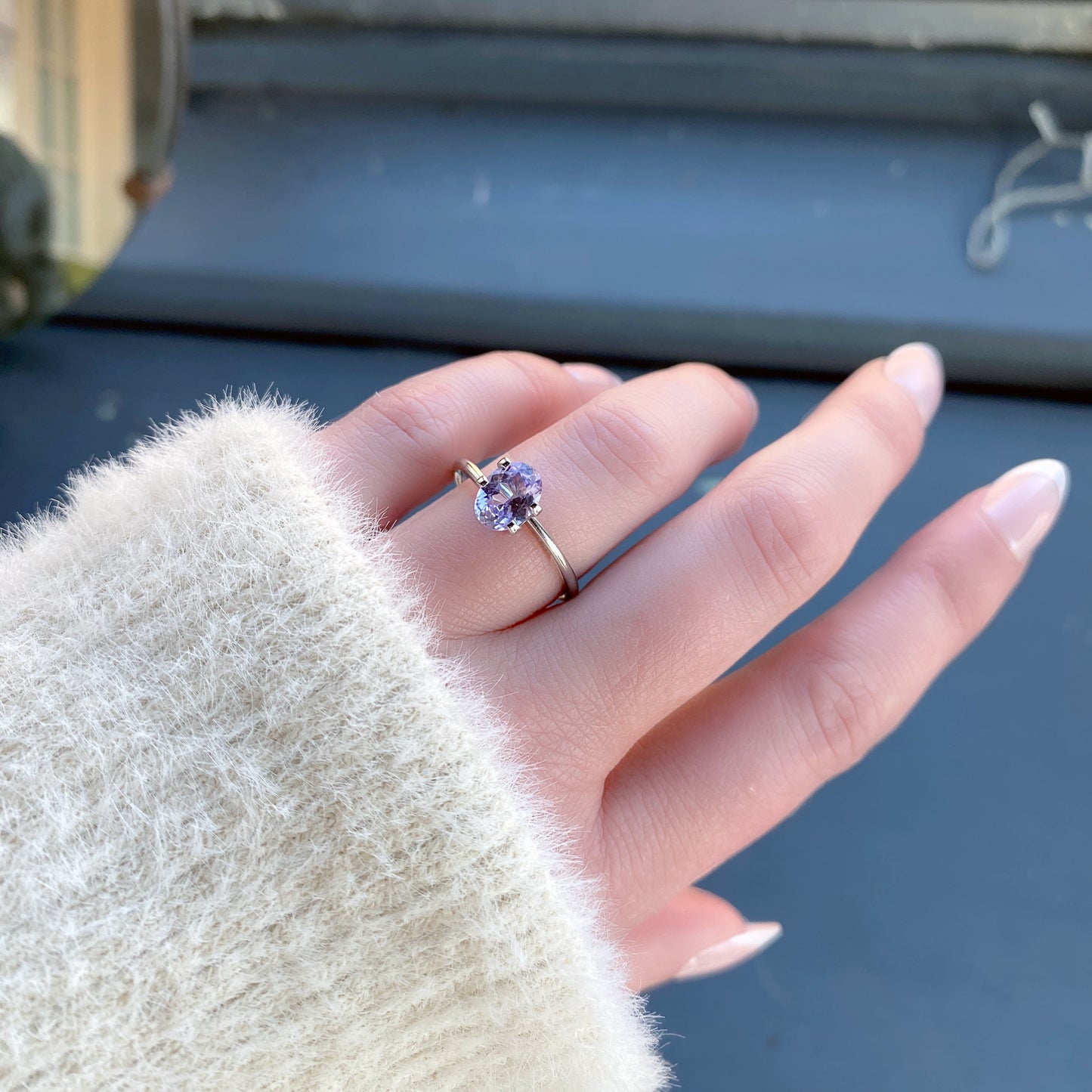 a 1.19 ct oval lavender sapphire in a temporary ring mounting in diffused winter sunlight