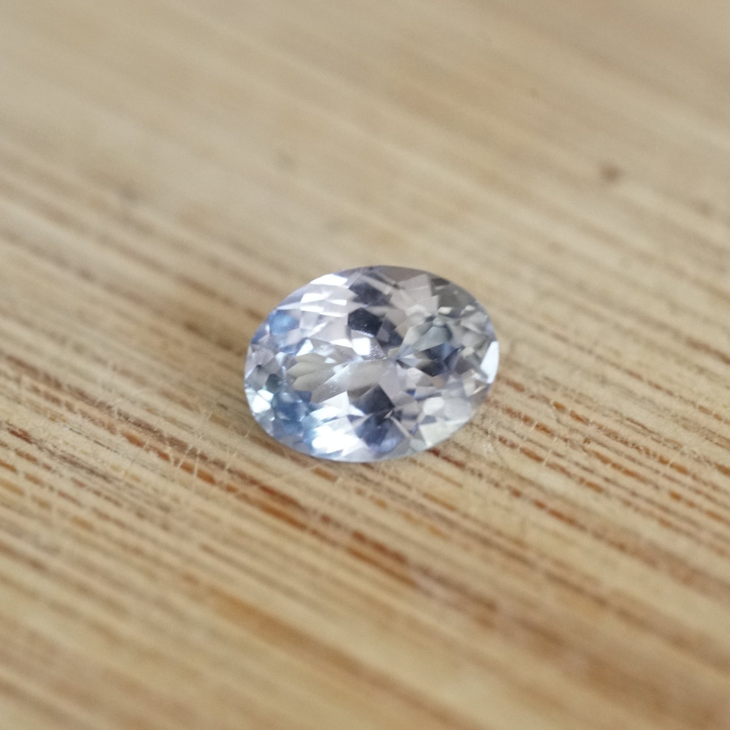 a 1.34 ct ice blue sapphire rests on a wood base