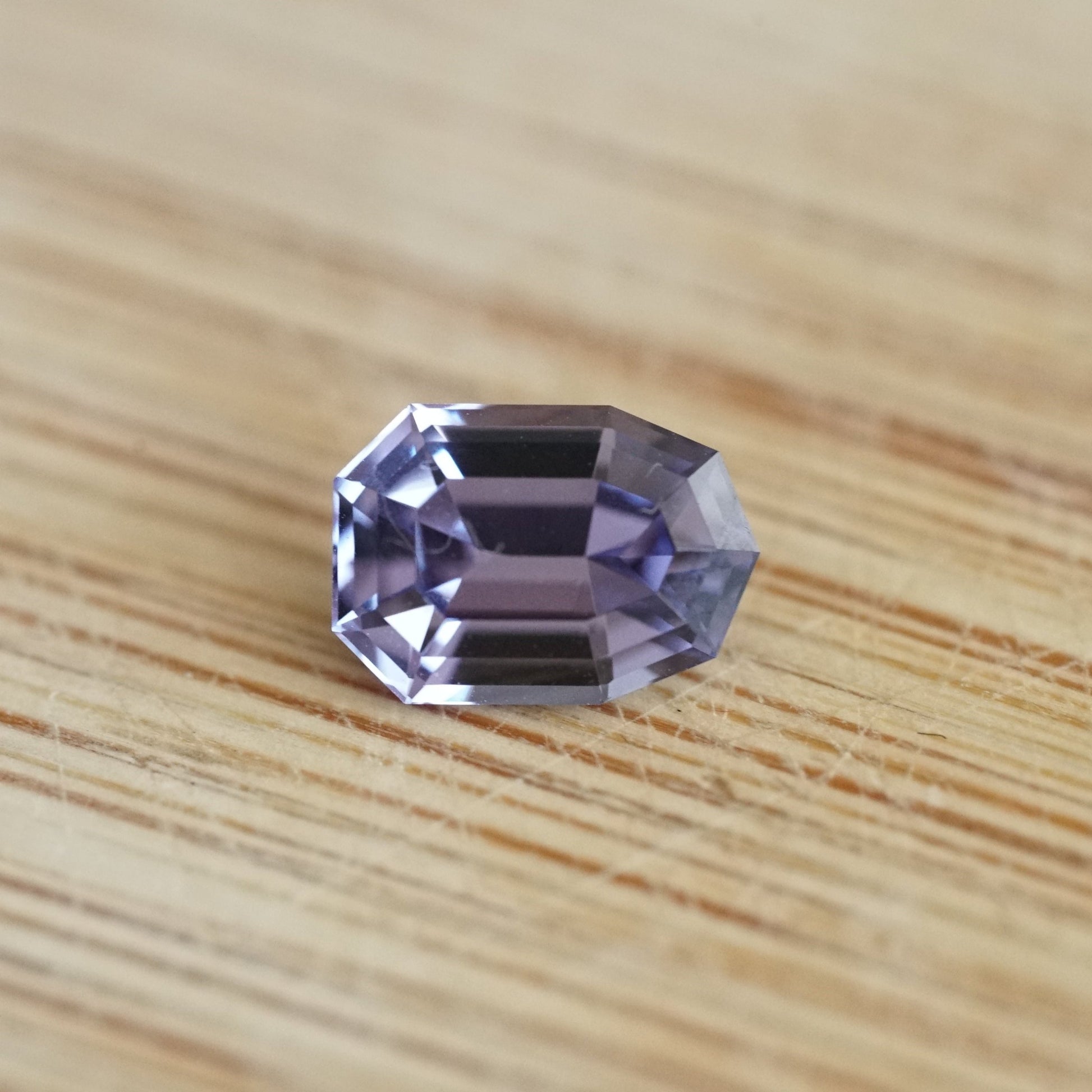 a 1.38 ct violet spinel rests on a wood base