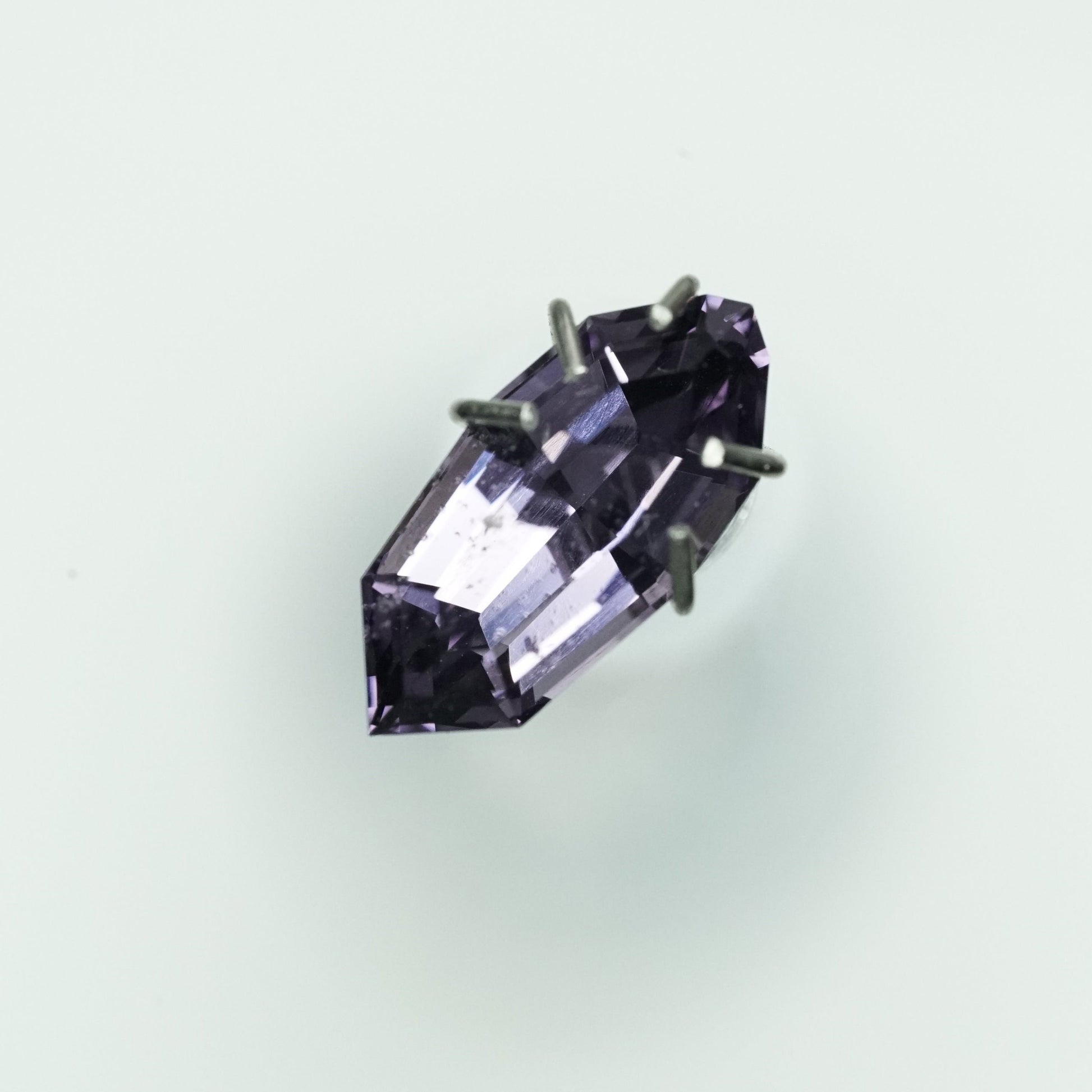 a 1.57 ct violet spinel in a temporary ring mounting in bright fluorescent light