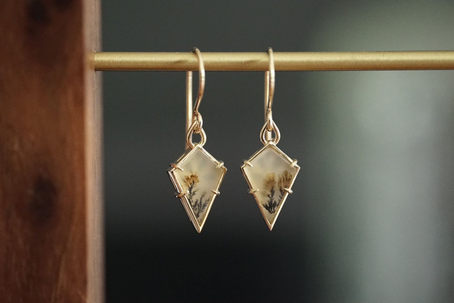 Pair of geometric earrings on a dark background