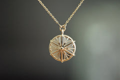 Gold necklace with a circular pendant on a dark background