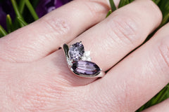 Ring with purple gemstones on a hand against a blurred natural background