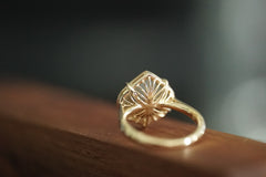 Gold ring with intricate design on a wooden surface