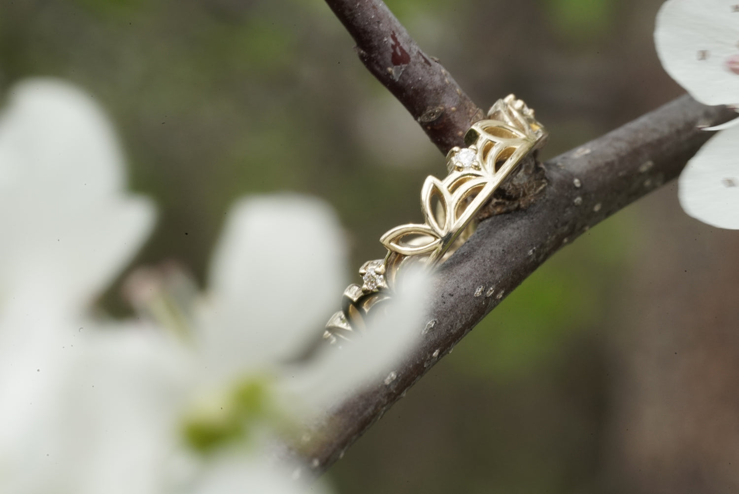 Gold ring with floral design on a branch with white flowers
