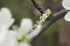 Gold ring with floral design on a branch with white flowers