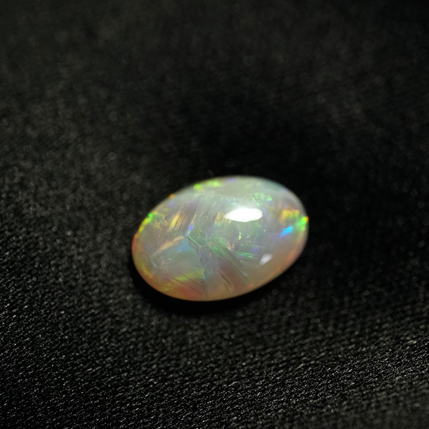 a 2.03 ct oval opal on a black backdrop