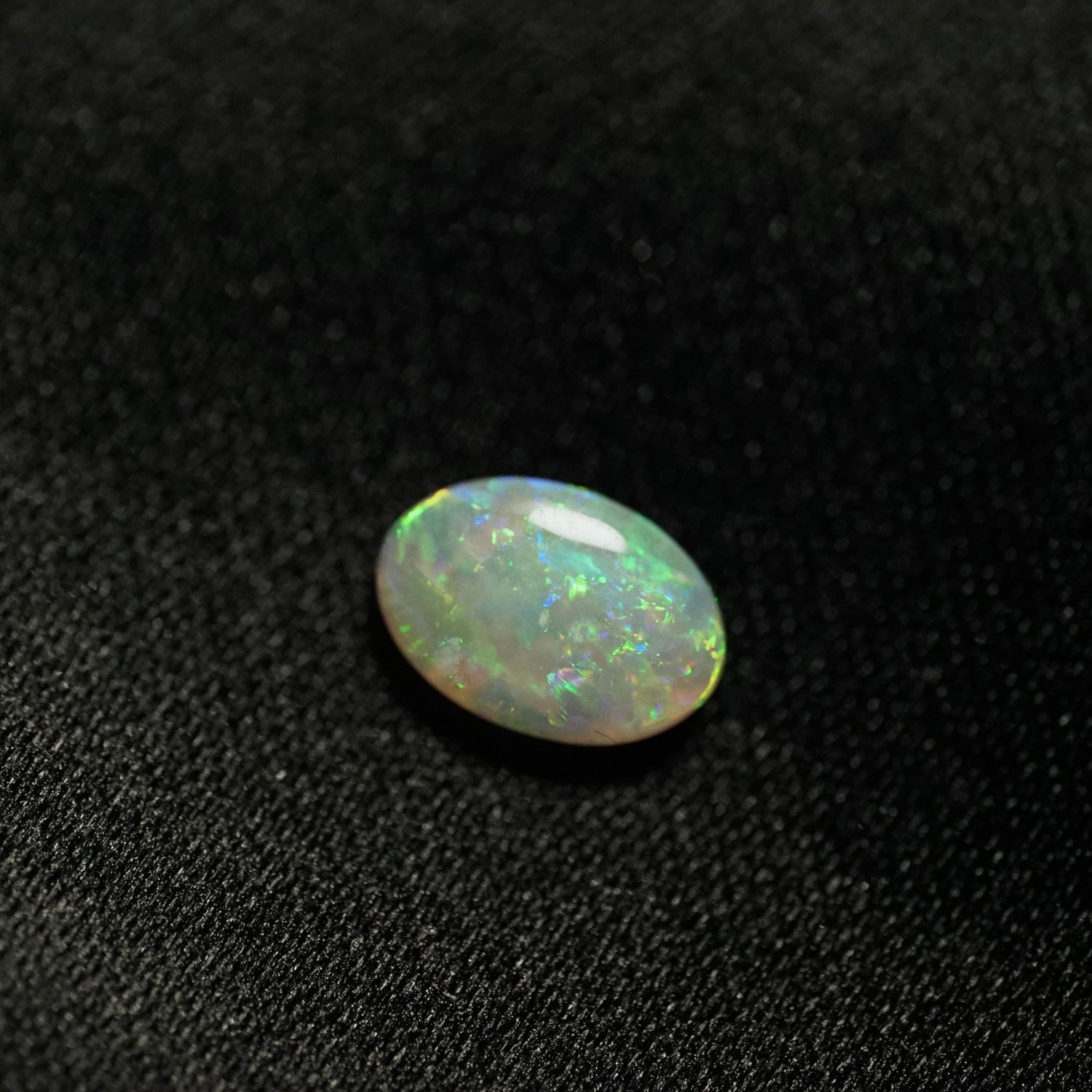 a 1.24 ct oval opal  on a black backdrop