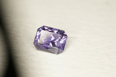 Purple gemstone on a light gray background