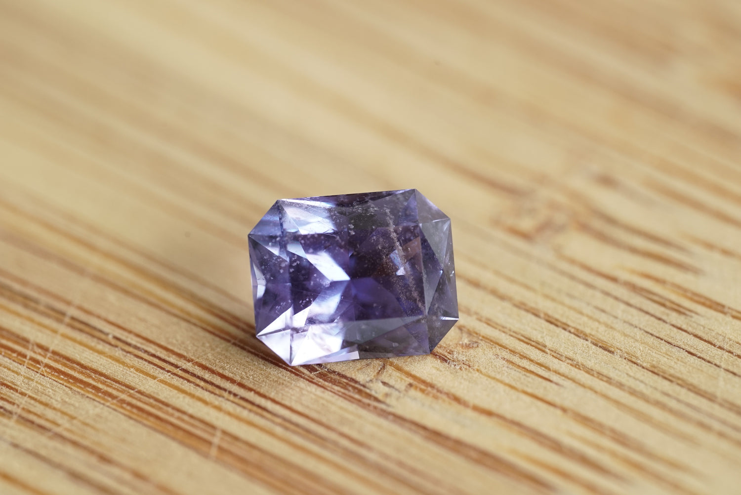Purple gemstone on a wooden surface