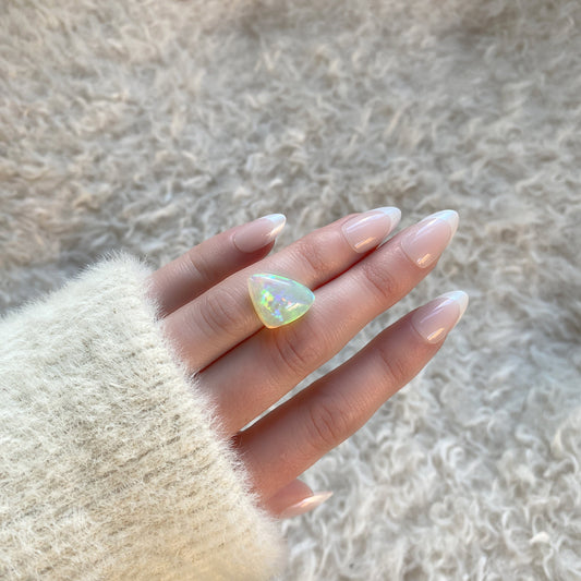 an 8.73 ct triangular opal is shown in diffused winter sunlight