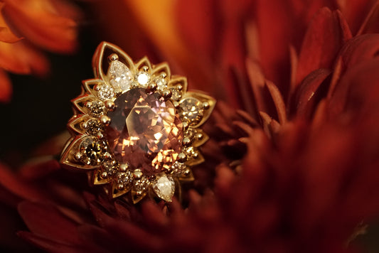 a magnificent 18K yellow gold ring with an oval chocolate zircon center stone surrounded by round and pear shape diamonds which color fade from brown to white in a floral halo