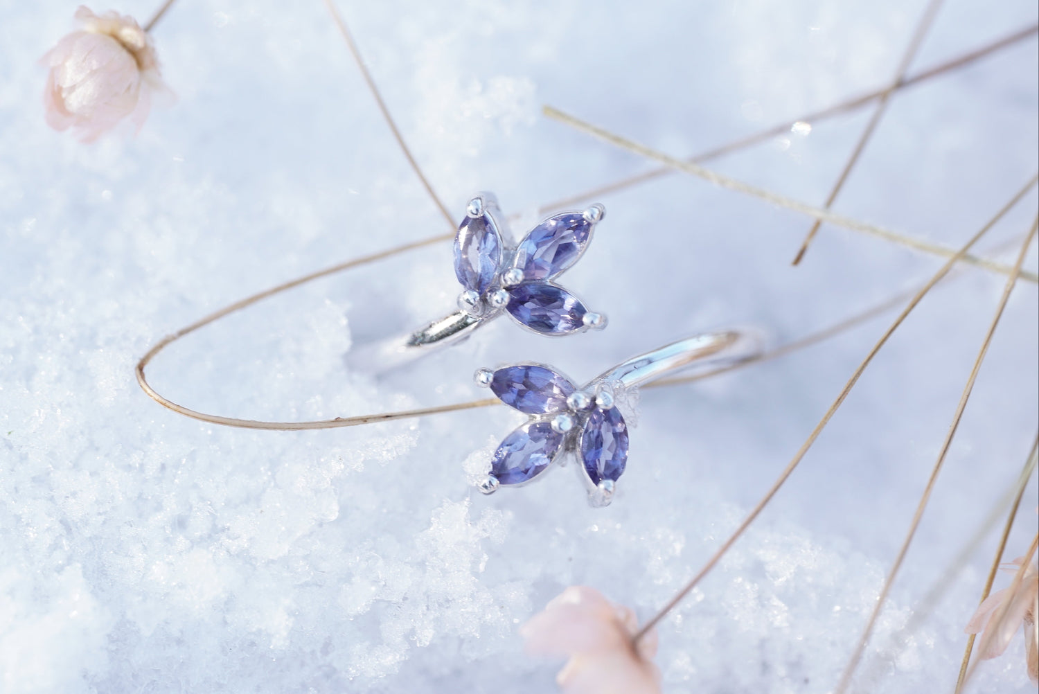 A white gold and iolite ring rests lightly in the snow