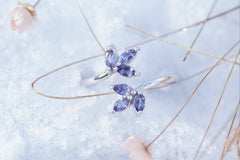 A white gold and iolite ring rests lightly in the snow