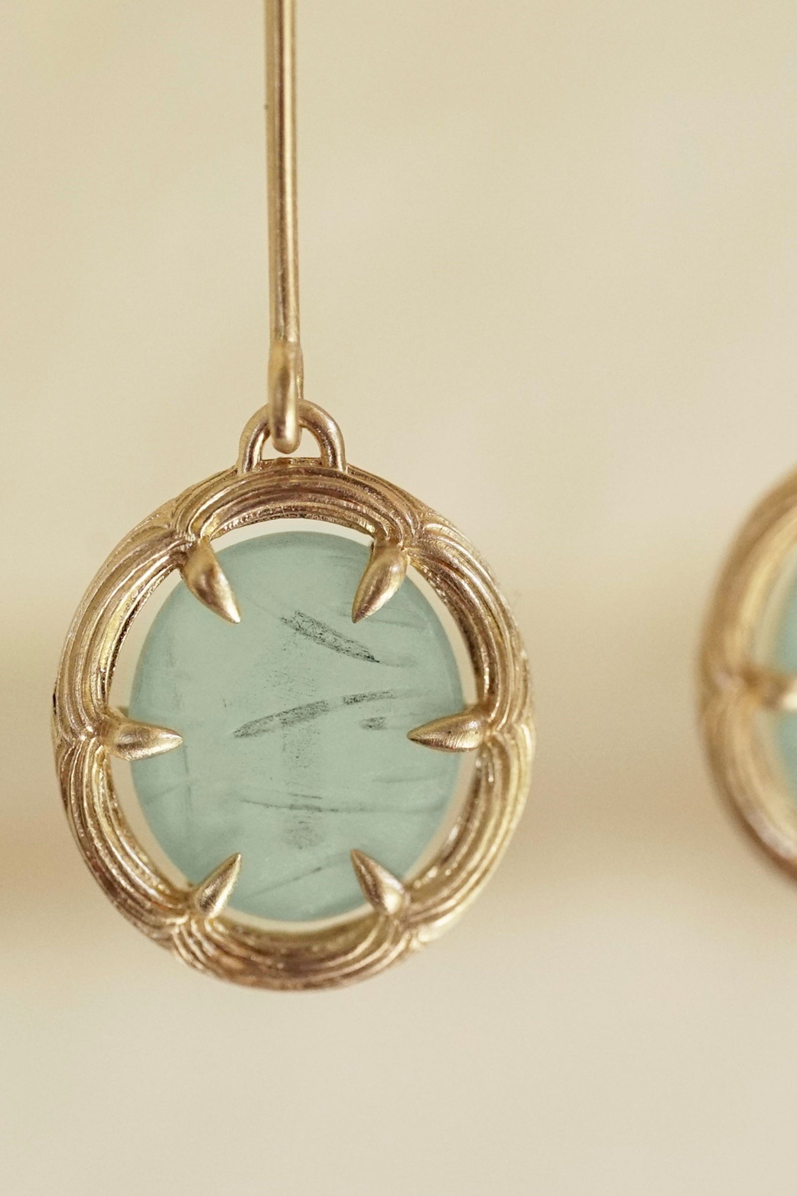 a yellow gold and carved jade drop earring