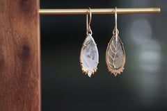Teardrop-shaped earrings on a dark background