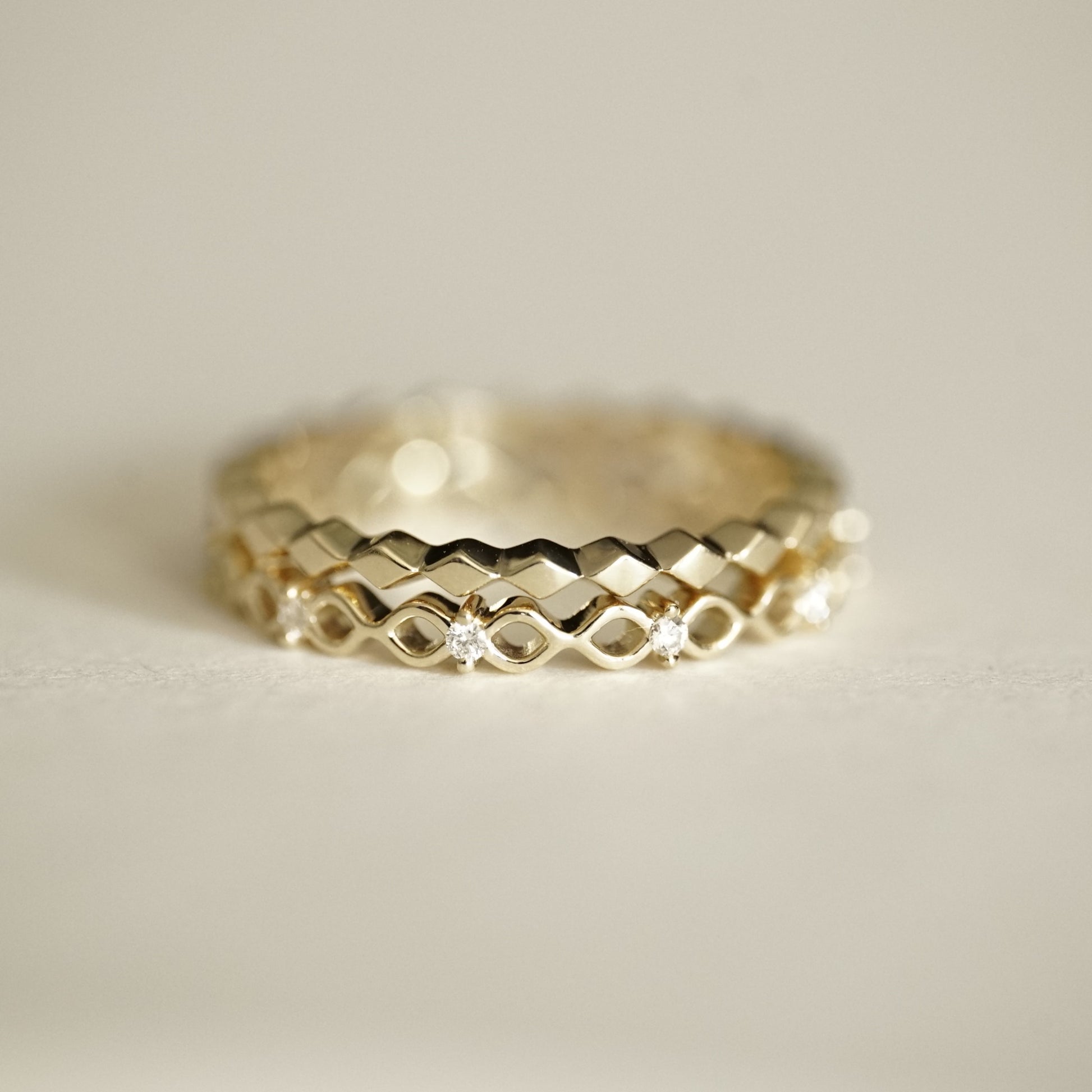 a yellow gold and diamond band is stacked with a yellow gold diamond element band