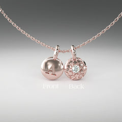 A computer rendering of a pair of rose gold and diamond pendants on a chain