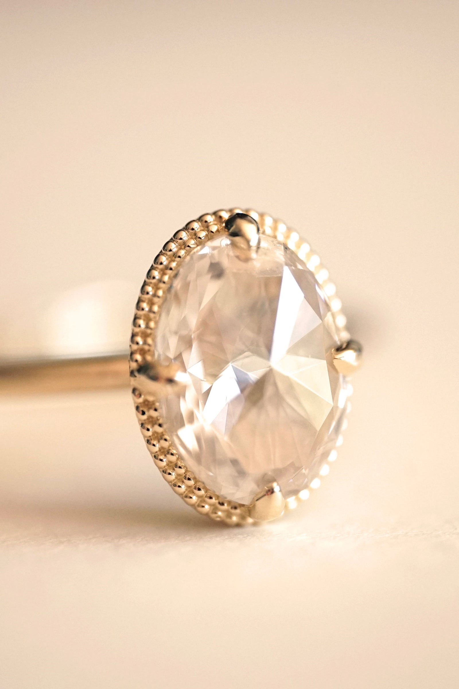 a yellow gold and rose cut diamond engagement ring on a white groundplane