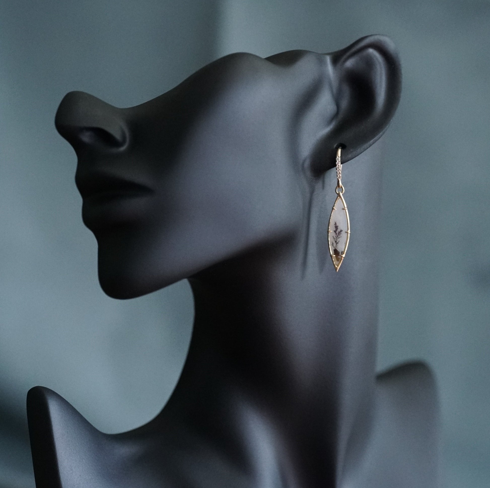 a yellow gold drop earring featuring dendritic agates and diamond drop tops displayed on a manikin for scale