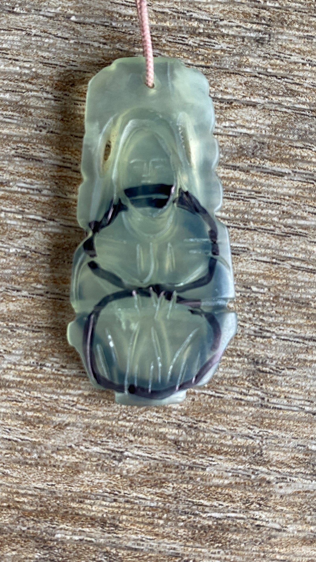 an heirloom jade pendant carved with a human figure has been drawn on to outline custom cut cabochons