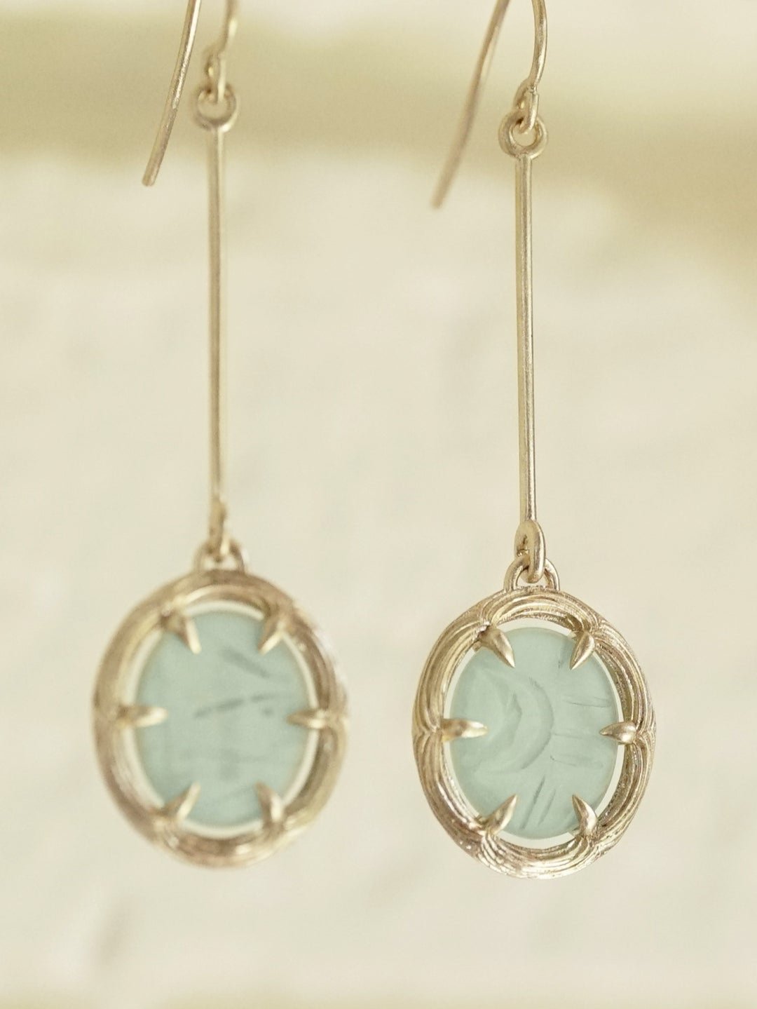 a pair of 14K yellow gold and jade drop earrings with custom carved jade cabochons in the center