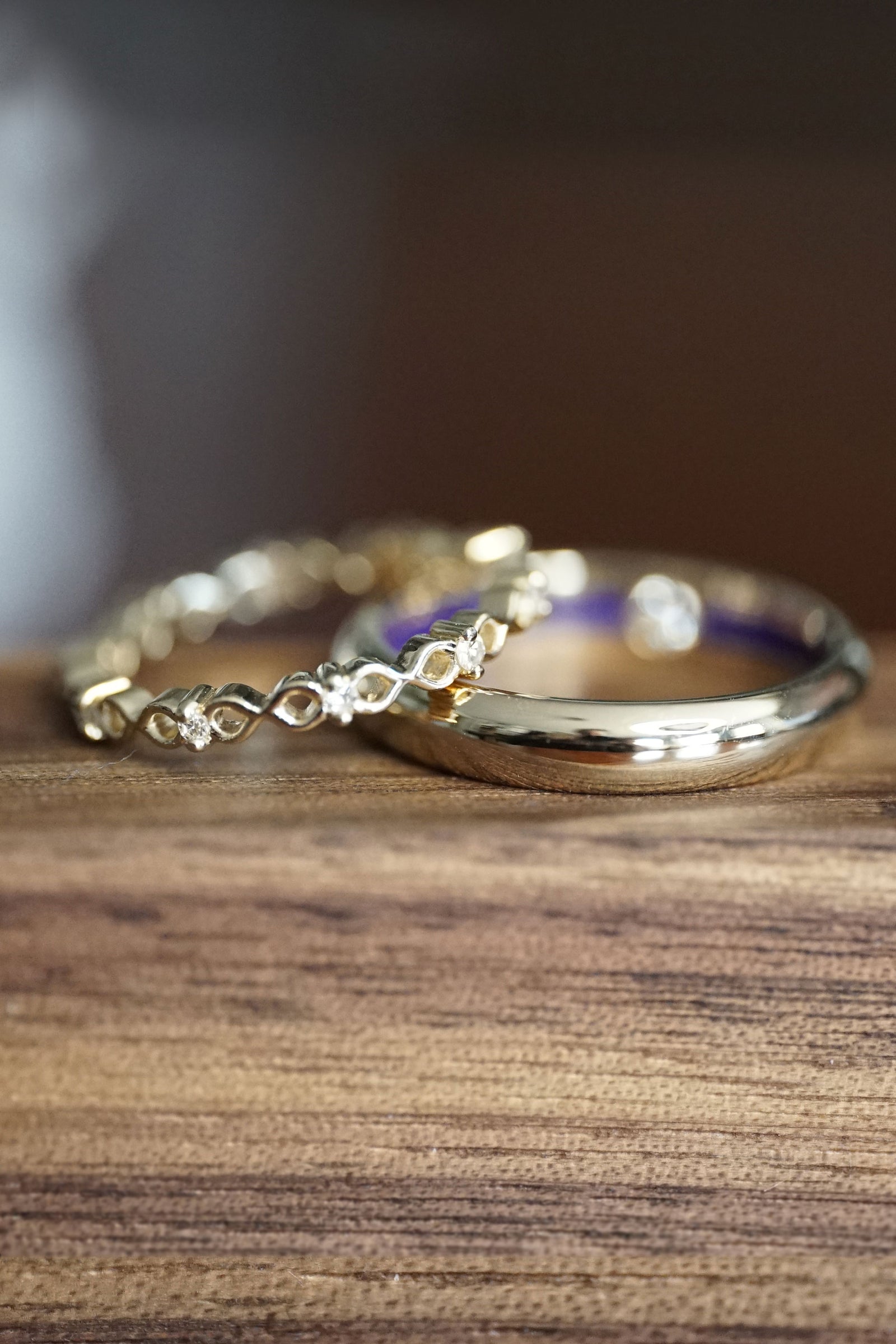 a yellow gold and diamond wedding band set on a wooden display