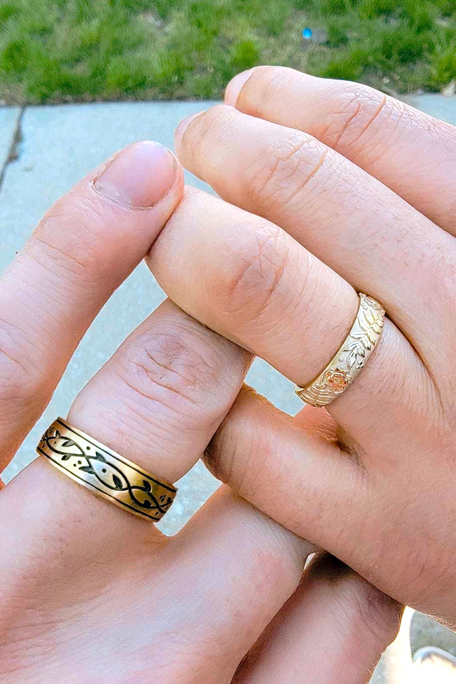 a pair of yellow gold wedding bands on light skin tone hands
