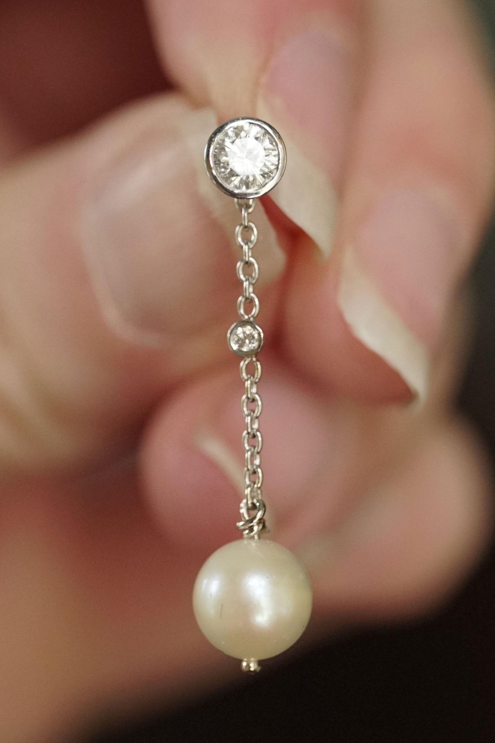a white gold diamond and pearl drop earring