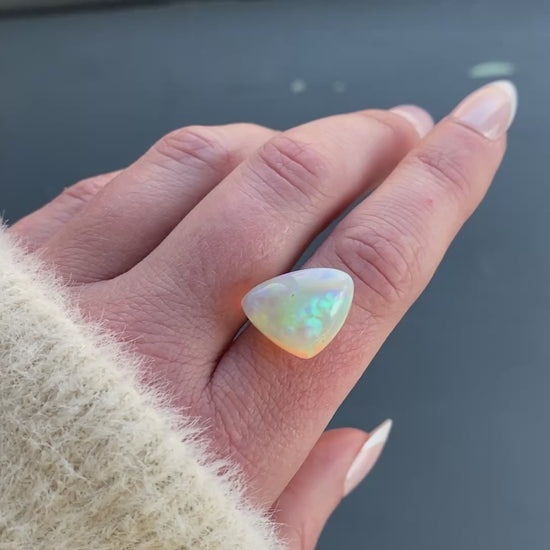 an 8.73 ct triangular opal is shown in diffused winter sunlight