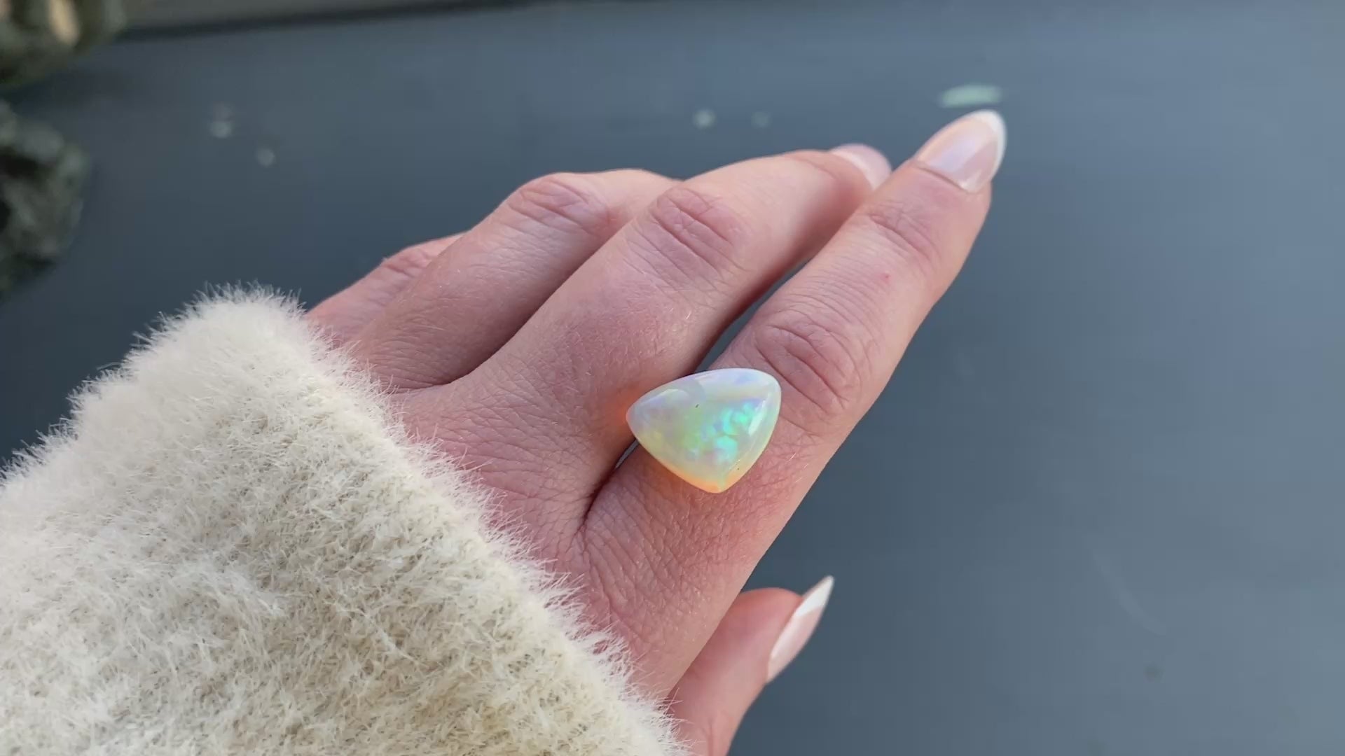 an 8.73 ct triangular opal is shown in diffused winter sunlight