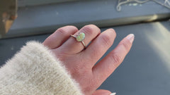a 1.24 ct oval opal is shown in a temporary ring mount in diffused winter sunlight