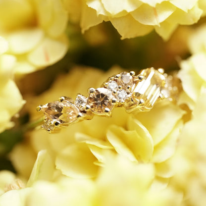 a yellow gold ring with yellow gems of mixed cuts and sizes are paired with white diamonds in yellow flowers