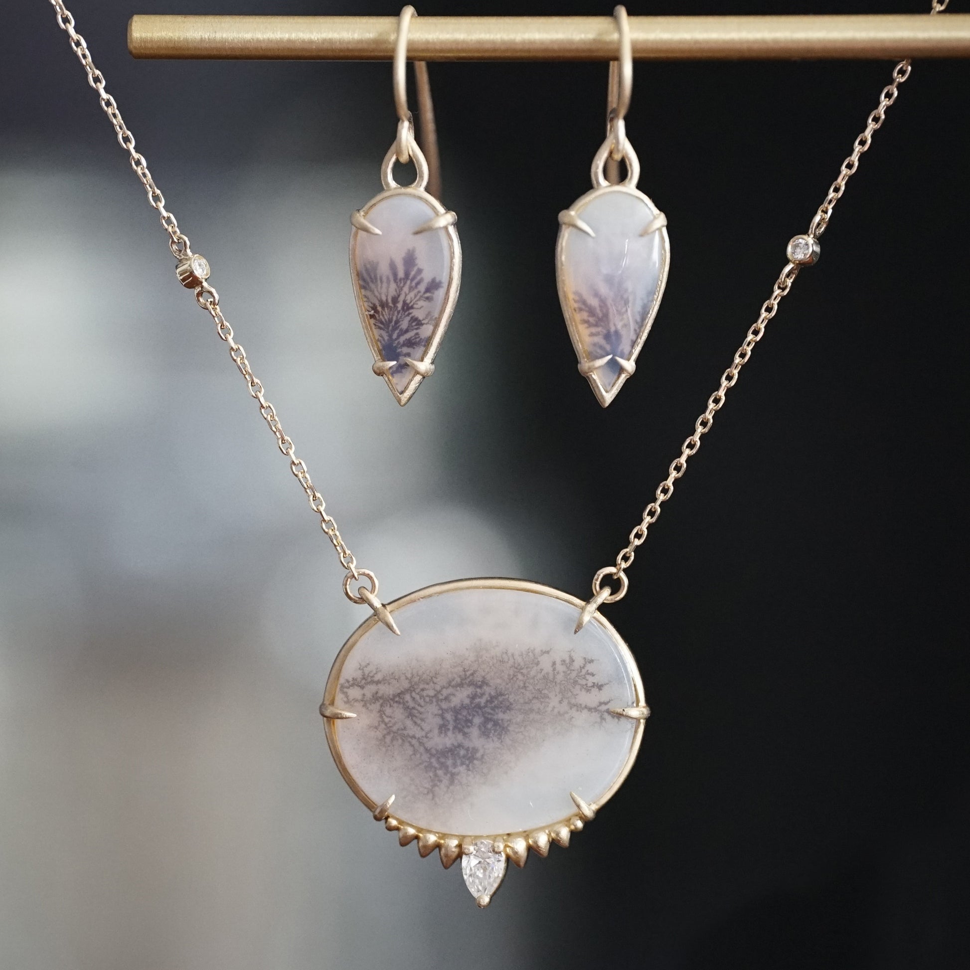 a yellow gold, dendritic agate, and diamond necklace and a pair of yellow gold and dendritic agate earrings make up this lovely matched set